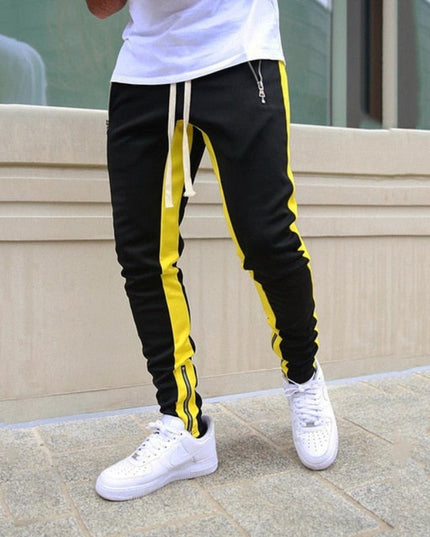 Sportowe dresy męskie z ozdobnym lampasem i suwakiem na nogawce